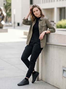 Slim-fit black joggers and a fitted graphic tee under an unbuttoned olive utility shirt for a relaxed yet put-together weekend outfit.