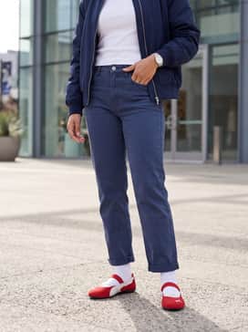 Cropped straight-leg light-wash jeans with a crisp white baby tee and a navy blue oversized bomber jacket to make the red shoes the focal point.