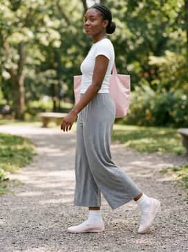 Speedcat Ballet Venus Womens Sneakers – Dove grey wide-leg loungewear trousers paired with a white ribbed baby tee and a structured pink tote bag for a comfortable yet elevated athleisure ensemble.