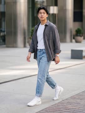 Baggy light-wash jeans, a tight-fitting white baby tee, and silver jewelry for a complete Y2K revival look.