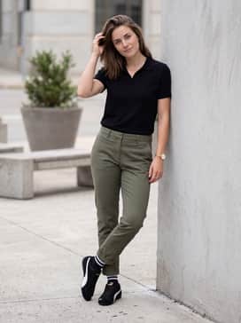 Speedcat Og – Olive green tailored chinos with a tucked-in black polo shirt and a minimalist gold watch to complement the shoe's metallic accents.
