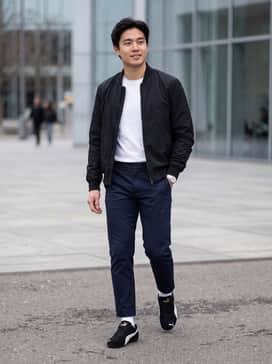Slim-fit dark indigo jeans paired with a crisp white t-shirt and a black nylon bomber jacket for a classic street look.