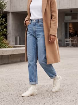 Classic high-waisted straight-leg denim in a light wash paired with a crisp white t-shirt and a camel-colored wool coat for a timeless weekend aesthetic.