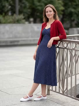 Stan Smith Lo Pro Shoes – A flowy navy and white polka dot midi dress with a red cropped cardigan for a vintage-inspired daytime ensemble.