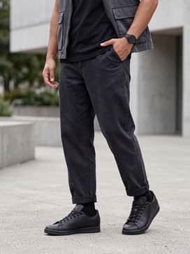 Style with tapered olive cargo pants, a heavy-weight black graphic t-shirt, and a utility vest for a modern streetwear vibe.