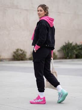 Stewie 4 Timeless – A sleek athleisure outfit consisting of high-waisted black yoga leggings, a cropped hot pink hoodie, and silver minimalist jewelry for a clean yet vibrant urban look.