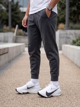 Streakfly 2 – A sleek training outfit featuring charcoal grey tapered tech-fleece joggers, a fitted black moisture-wicking long-sleeve top, and a white performance headband.