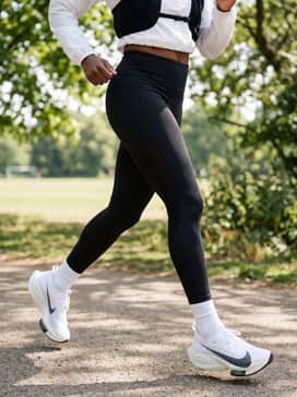 Streakfly 2 – A modern technical aesthetic pairing black high-waisted compression leggings with a cropped white quarter-zip windbreaker and a sleek black hydration vest.