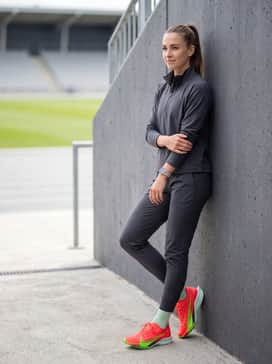 A sleek track-side warm-up outfit with slim-fit tapered joggers and a quarter-zip technical pullover in a neutral charcoal grey.