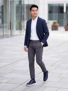 Street Lite – A tailored pair of charcoal grey chinos paired with a crisp white button-down shirt and a navy unstructured blazer for a sophisticated office-ready look.