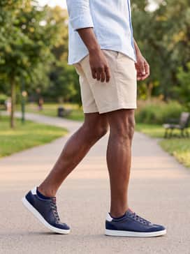 Beige tailored shorts and a linen shirt in a light pastel shade, perfect for a coastal vacation or an upscale summer brunch.