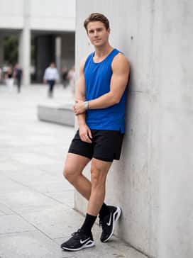 Structure 26 – An intense workout outfit pairing black 7-inch lined running shorts with a vibrant cobalt blue singlet and moisture-wicking crew socks to highlight the shoes' sleek profile.