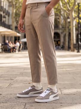Suede Classic – Beige tailored trousers, a cream lightweight turtleneck sweater, and a long camel wool coat for a sophisticated tonal look.