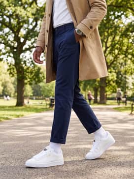 Suede Xl Leather – Tailored navy chinos worn with a crisp white button-down shirt and a tan trench coat for a sophisticated high-low smart-casual ensemble.