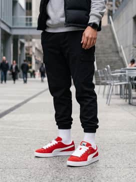 Black tapered cargo joggers worn with a grey heathered hoodie and a black puffer vest for a layered, functional urban look.