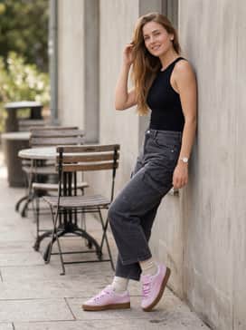 High-waisted charcoal grey cargo pants and a fitted black bodysuit, allowing the vibrant pink and gum sole to stand out as the focal point.