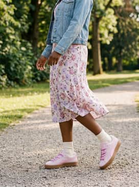 A floral midi dress featuring hints of lilac and rose, topped with a light-wash denim jacket for a perfectly balanced feminine and casual weekend ensemble.