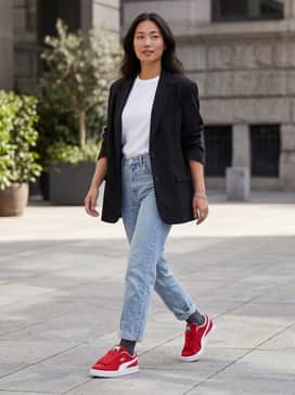 High-waisted light-wash straight-leg jeans paired with a tucked-in white graphic tee and an oversized black blazer for a sophisticated street look.