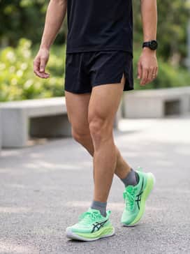 A sleek marathon-ready look featuring black 3-inch split shorts, a matching black moisture-wicking mesh singlet, and a high-performance GPS running watch.