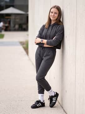 Superstar Ii Shoes – Charcoal grey tapered joggers and a matching cropped hoodie, styled with white crew socks pulled over the hems for a modern sporty aesthetic.