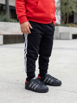 For a sporty vibe, combine them with black jogger pants featuring white side stripes and a vibrant red hoodie that pulls from the shoe's heel accent.