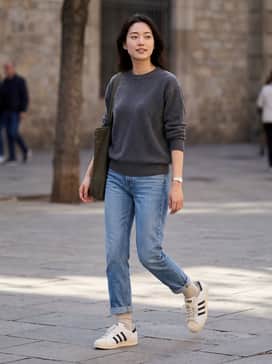 A pair of light-wash straight-leg jeans, a tucked-in vintage graphic tee, and an unbuttoned navy flannel shirt for a classic 90s-inspired streetwear look.