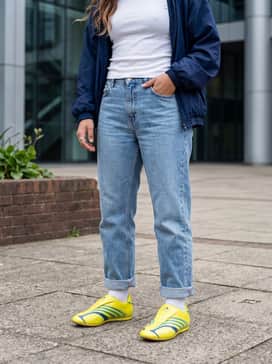 Taekwondo F50 Shoes – A modern streetwear look with oversized light-wash straight-leg jeans, a fitted white 'baby tee', and a vintage navy blue windbreaker that complements the blue gradient stripes on the shoes.