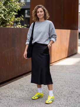 Taekwondo F50 Shoes – A balanced casual-chic outfit consisting of a black satin midi slip skirt, an oversized grey marl sweatshirt tucked at the waist, and minimalist silver accessories for a mix of textures.