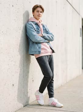 Style with charcoal grey joggers, a coordinated pastel pink hoodie, and a light-wash denim jacket for a comfortable and trendy school outfit.