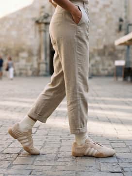 Neutral-toned tapered cargo joggers combined with a fitted black bodysuit and a cropped utility jacket to emphasize the shoe's sleek silhouette.