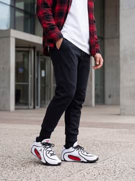 Tatum 4 – Tapered black tech-fleece joggers paired with a crisp white oversized graphic tee and a red flannel shirt worn open.