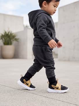 Team Hustle D 12 – A mini Nike Tech Fleece set in dark charcoal grey with black accents, creating a streamlined, athletic silhouette that complements the sneaker's sporty design.