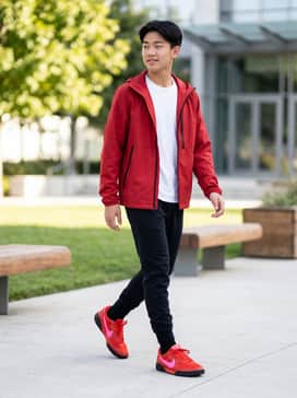 Black tech-fleece joggers paired with a matching red windbreaker and a simple white tee for a cohesive athletic look.