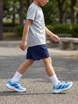 A sporty performance look featuring navy blue mesh shorts, a breathable grey graphic tee, and white moisture-wicking crew socks for a day of active play.