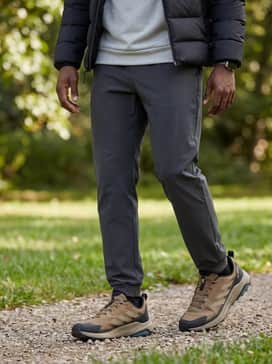A sleek travel-ready set including black tapered tech joggers, a light grey moisture-wicking performance hoodie, and a structured black water-resistant puffer jacket for ultimate comfort on the go.