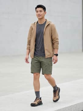 Durable olive cargo shorts paired with a moisture-wicking charcoal performance t-shirt and a lightweight tan windbreaker for trail versatility.