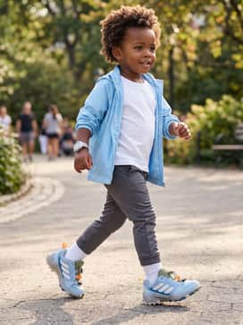 A sporty athletic kit with black moisture-wicking leggings, a breathable white mesh tank top, and a lightweight blue windbreaker for cooler mornings.