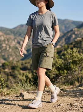 A rugged outdoor look featuring olive green cargo shorts, a moisture-wicking grey performance tee, and a wide-brimmed sun hat for trail protection.