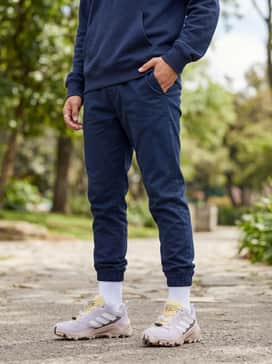 A comfortable athleisure outfit consisting of navy blue tapered joggers, a matching zip-up hoodie, and white crew socks for a clean athletic finish.