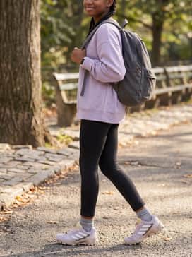 A functional school-day style pairing black athletic leggings with an oversized lavender sweatshirt and a durable backpack for a coordinated, practical aesthetic.