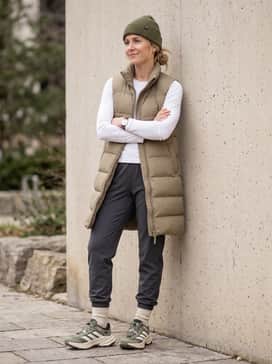 Terrex Freehiker Sl Goretex Hiking Shoes – Distressed charcoal grey joggers and a crisp white graphic tee topped with a longline khaki puffer vest for a functional urban streetwear look.