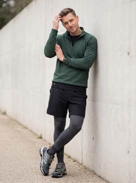 Terrex Skychaser Hiking Shoes – Technical black hiking shorts worn over grey compression leggings with a breathable forest green quarter-zip fleece for cooler morning excursions.