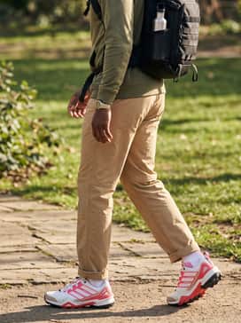 Terrex Skychaser X Shmoofoil Goretex Hiking Shoes – A casual outdoor weekend style with tan nylon hiking pants, a olive green sun-protection hoodie, and a functional black backpack for a balanced utilitarian vibe.