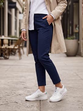 The Roger Adv Z5 – Slim-fit navy chinos with a crisp white Oxford shirt worn untucked and a lightweight beige trench coat for a polished, smart-casual aesthetic.
