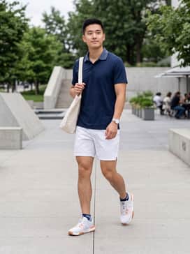 The Roger Advantage Pro – White performance tennis shorts paired with a moisture-wicking navy polo shirt and low-cut athletic socks for a classic court-ready look.