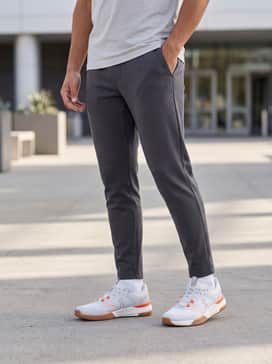 Tapered charcoal grey joggers and a slim-fit light grey hoodie, creating a sleek athleisure ensemble perfect for errands or travel.