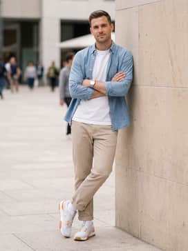 Sand-colored straight-leg chinos with a crisp white t-shirt and an open light blue chambray button-down for a smart-casual weekend aesthetic.