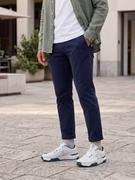 The Roger Advantage Pro – A refined weekend outfit consisting of slim-fit navy chinos, a crisp white pima cotton t-shirt, and an unbuttoned sage green linen shirt for a layered, textured appearance.