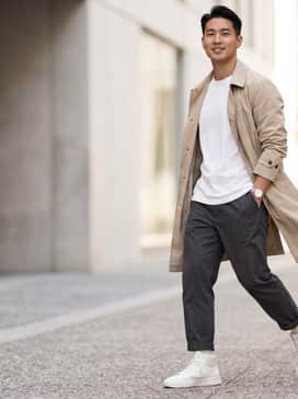 Slim-fit charcoal chinos, a crisp white organic cotton t-shirt, and a lightweight beige trench coat for a sophisticated urban look.