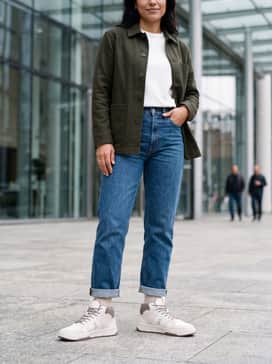 Style with light-wash distressed straight-leg jeans, a white heavyweight tee, and an unbuttoned olive green chore coat for a rugged streetwear vibe.